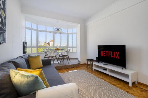a living room with a couch and a television at WHome Peaceful River Views in Algés perfect for Families in Algés