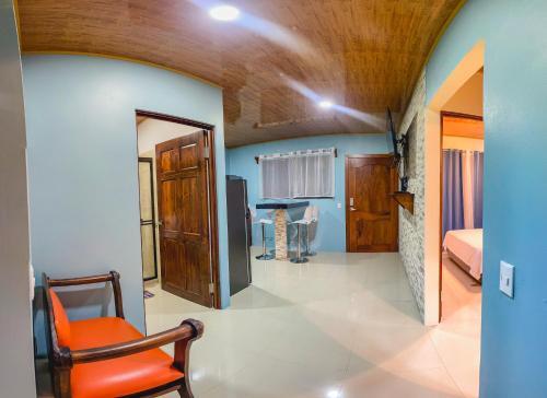 een woonkamer met een oranje stoel in een kamer bij La Fortuna Donwtown Dreams in Fortuna