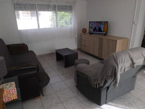 sala de estar con sofá y TV en Aux portes de la Soufrière, Baillif en Baillif