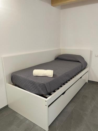 a white platform bed with a gray blanket on it at Delfina Home giardino 013239-CNI-00130 in Vercana