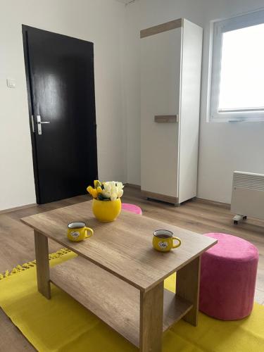 a living room with a wooden table and a yellow bowl of fruit at Dedina kuća in Gornji Milanovac