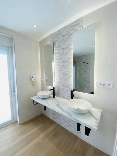 a bathroom with two sinks and a large mirror at Arunda Home in Ronda