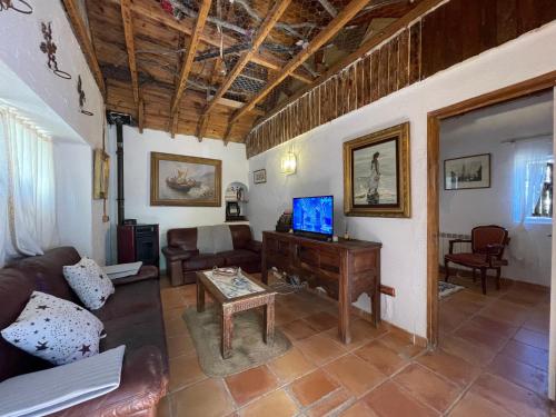 a living room with a couch and a tv at Casa Fidelina I Miraflores de la Sierra in Madrid