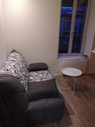 - un canapé noir dans le salon avec une table dans l'établissement Résidence du Panthéon, à Le Mont-Dore