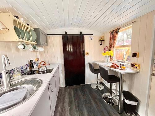 a small kitchen with a sink and a red door at Alice’s Garden @ Bleak House Farm in York