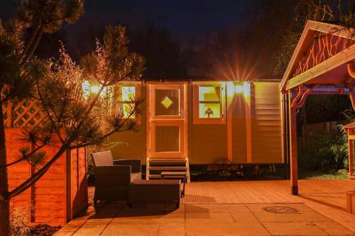 a tiny house sitting on a patio at night at Alice’s Garden @ Bleak House Farm in York