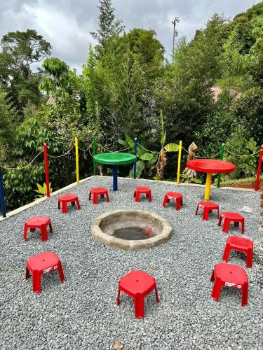 a playground with red and green tables and red stools at Finca Villa Maju K24 Vista naturaleza clima delicioso A 30 min Cali in Papagalleros