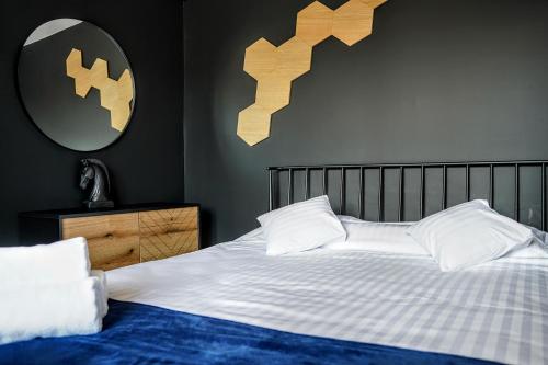 1 dormitorio con 1 cama con sábanas blancas y espejo en Apartament 914, en Wisła