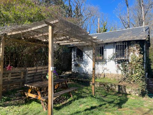 a wooden pergola and a picnic table in front of a house at Casa Fidelina I Miraflores de la Sierra in Madrid