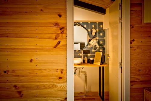 a bathroom with wooden walls and a vanity with a mirror at Hotel Casa Luna in Zafra