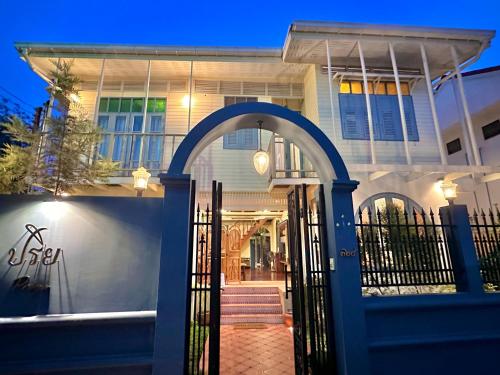 a house with a blue gate in front of it at Priya Boutique House in Bangkok