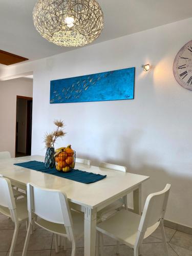 a dining room with a white table and chairs at Villa Mihaela - Apartment Mario in Cesarica