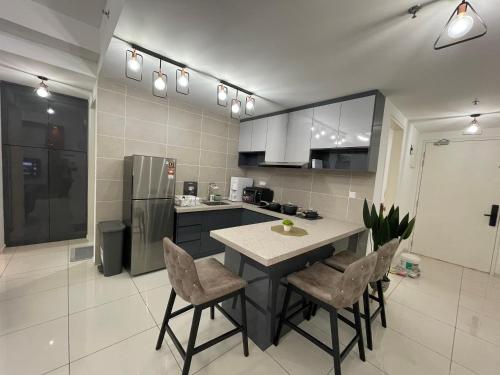 a kitchen with a table and chairs and a refrigerator at Ipoh Sunway Onsen Suites and Tambun Guesthouse , 3-14pax 2parking by IWH in Ipoh