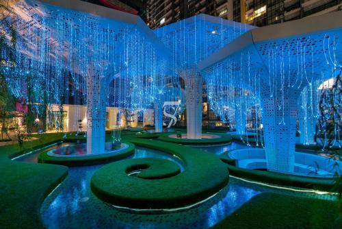 a building with blue lights and a fountain at Kuala Lumpur Arte 3Bedrooms Master Residence in Kuala Lumpur