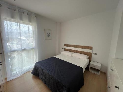 1 dormitorio con cama y ventana grande en Atico en Port gran Roses, en Roses