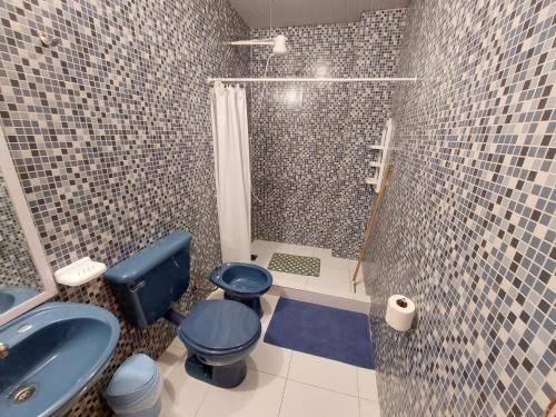 een badkamer met een blauw toilet en een douche bij Apart Morel in Puerto Iguazú