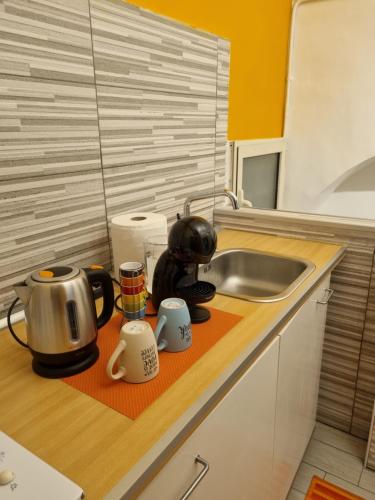 a kitchen counter with a sink and a tea kettle at majorana home in Naples
