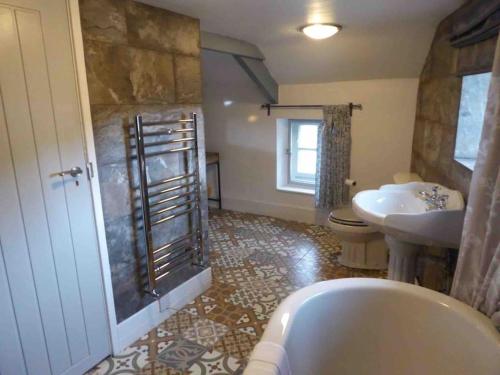 a bathroom with a tub and a toilet and a sink at Quirky Cottage in the Heart of Appleby in Appleby
