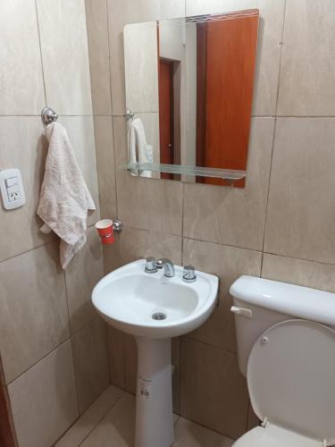 uma casa de banho com um lavatório, um WC e um espelho. em Hermoso alojamiento em Posadas