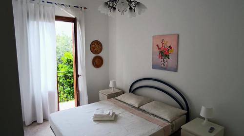 biała sypialnia z łóżkiem i oknem w obiekcie Casa VISTA MARE w mieście Macari