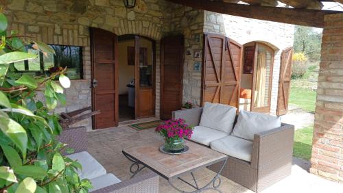 a patio with a couch and a table at Villa I Camini - Outbuilding, dependance - Swimming pool - Garden - BBQ and fireplaces - Soccer field in Monte Castello di Vibio