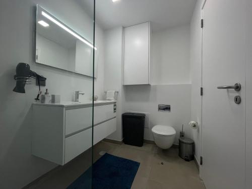 a white bathroom with a sink and a toilet at Sea and Sun 4 You - Jardins da Imperatriz in Funchal