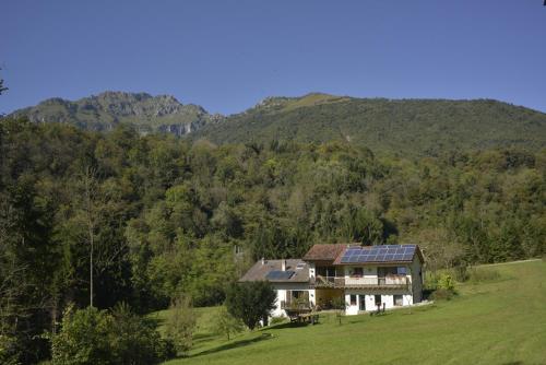 una casa en un campo con montañas en el fondo en Alla Casetta B&B, en Cesiomaggiore