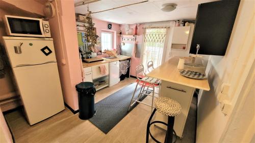 una pequeña cocina con nevera blanca y encimera en Appartement, atelier d'artiste, en Chelles