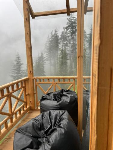 Zimmer mit 2 Schlafsäcken auf einem Balkon in der Unterkunft Cloudwalk Treehouse in Jibhi