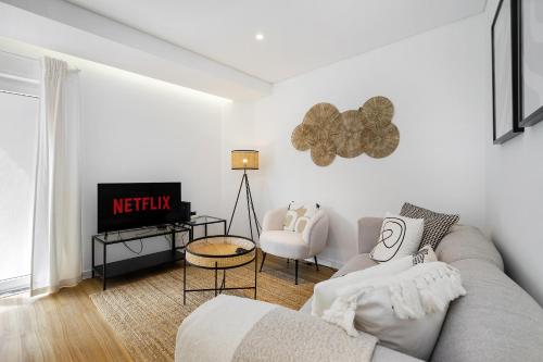 a living room with a couch and a tv at WHome Chic & Stylish Retreat in Estoril's Finest Location in Estoril
