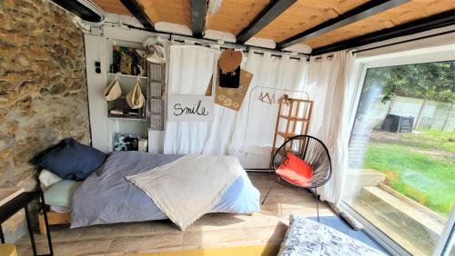 - une chambre avec un lit dans une pièce dotée d'une fenêtre dans l'établissement Appartement, atelier d'artiste, à Chelles