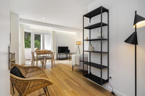 a living room with a black book shelf next to a bedroom at WHome Chic & Stylish Retreat in Estoril's Finest Location in Estoril