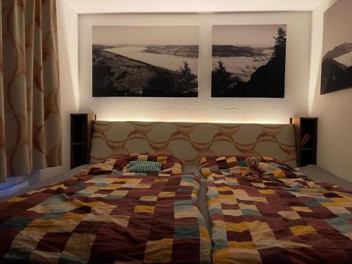 a bed in a bedroom with two pictures on the wall at Garden City Appartement in Salzburg