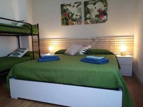 um quarto com uma cama verde com duas toalhas azuis em Casa Vacanze La Coccinella em Capo dʼOrlando