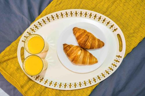 a plate with two croissants and a glass of orange juice at Modern flat in Moseley with Free Parking in Birmingham