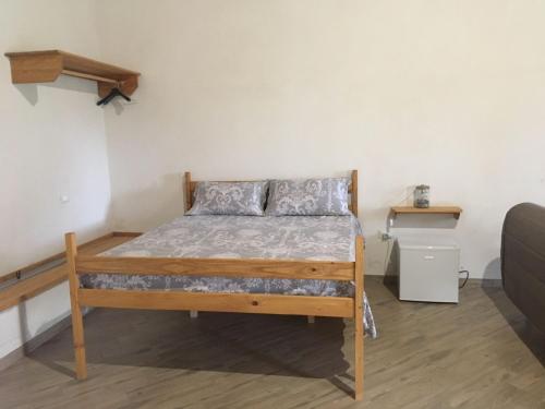 a bedroom with a bed with a wooden bed frame at Residence Le Tamerici in Cariati