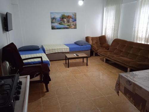 a living room with couches and a couch and a table at Samos Apart Pension in Guzelcamlı