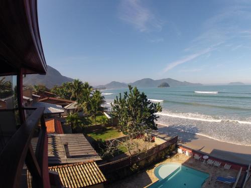a view of the beach from a balcony of a resort at Pousada Casa na Praia in Ubatuba