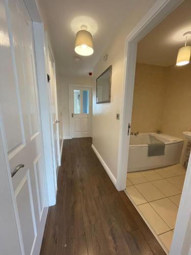 a hallway of a bathroom with a tub and a sink at Donard Point in Newcastle