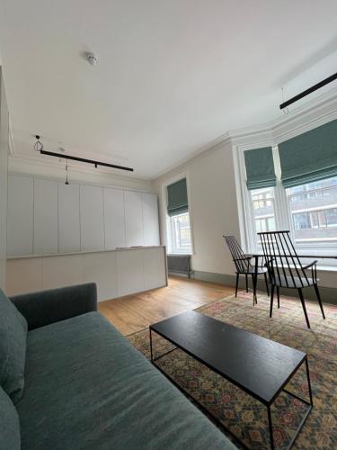 Regents Park Apartments في لندن: غرفة معيشة مع أريكة وطاولة وكراسي