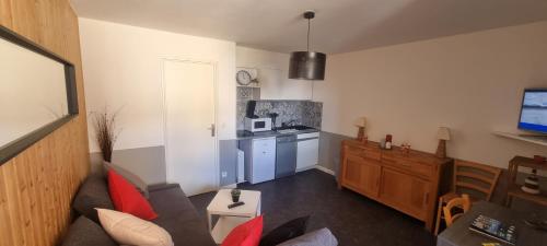Una sala de estar con un sofá y una cocina. en Studio 57, en Orcières