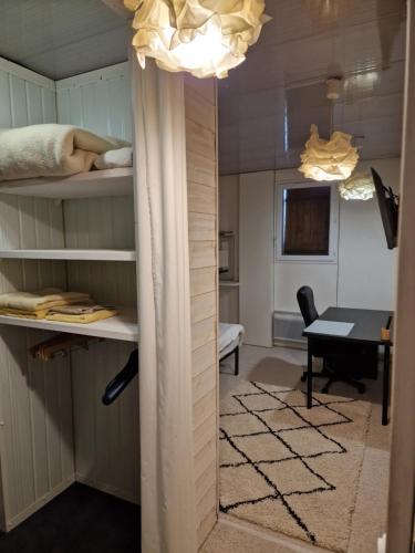 Cette chambre dispose de lits superposés et d'un bureau avec une table. dans l'établissement LES CERISIERS 2, à Nogaro