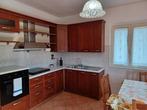 a kitchen with wooden cabinets and a sink at Villa Giulia - Cilento - Giungano in Giungano