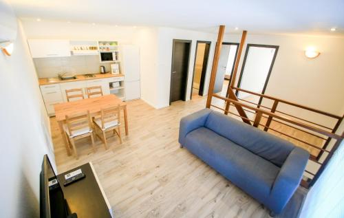 un soggiorno con divano blu e una cucina di VÁRLAK VENDÉGHÁZ Apartman 2 a Siófok
