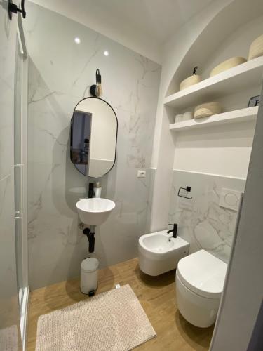 uma casa de banho com um WC, um lavatório e um espelho. em Il cortile tra i portici em Bolonha