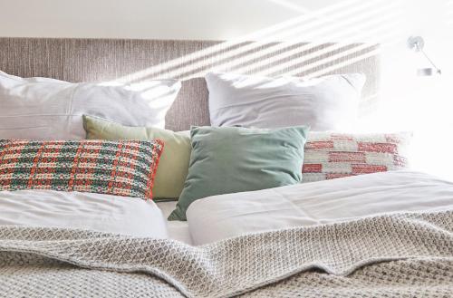 a bed with a bunch of pillows on it at Historischer Ohlerich Speicher Hafen Wismar Ap.18 in Wismar