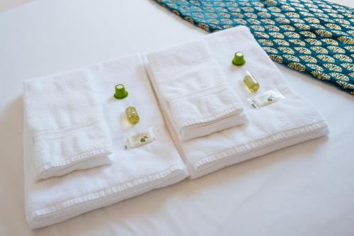 two white towels with green cherries on them at BeHappy Apartments in Lisbon