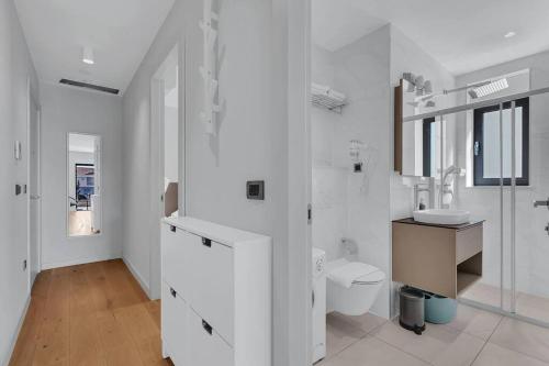 La salle de bains blanche est pourvue de toilettes et d'un lavabo. dans l'établissement Apartmani Vila Jelena 1, à Makarska