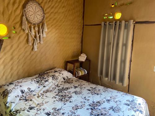 ein Schlafzimmer mit einem Bett mit einer blauen und weißen Decke in der Unterkunft Namastê Suítes e Chalés in Sao Jorge