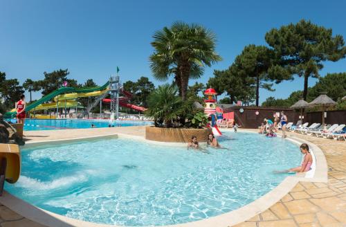 a group of people in a swimming pool at a theme park at Océan Mobilhome Siblu Bonne Anse Village Vacances La Palmyre in Les Mathes